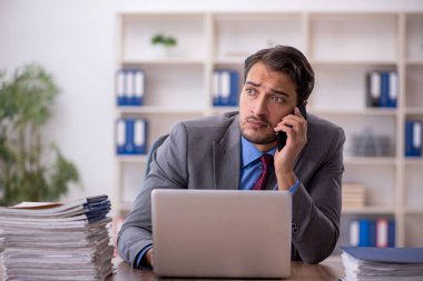 Genç işadamı işyerinde oturuyor.