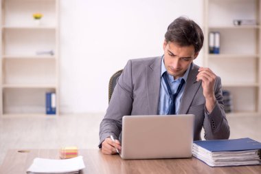 Genç işadamı işyerinde oturuyor.