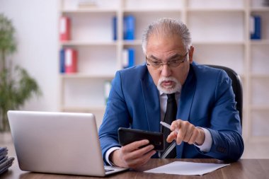 Ofiste çalışan eski bir işadamı.