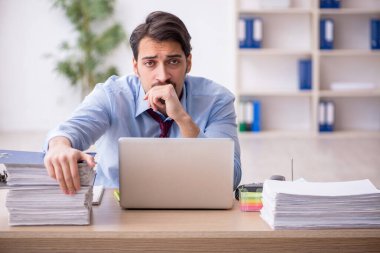 Genç bir çalışan ve ofiste çok fazla iş var.