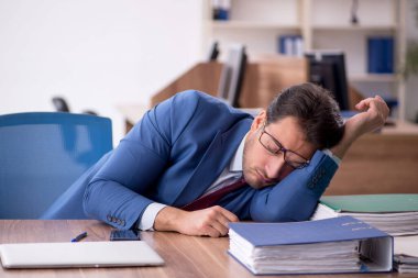 Genç işadamı işyerinde aşırı çalışmaktan memnun değil.