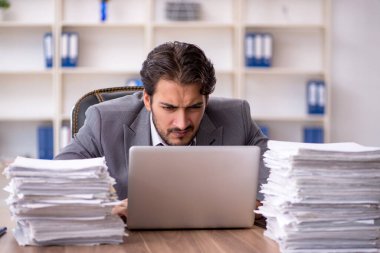 Genç işadamı ve ofiste çok fazla iş var.