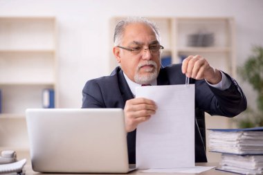 Ofiste çalışan eski bir işadamı.