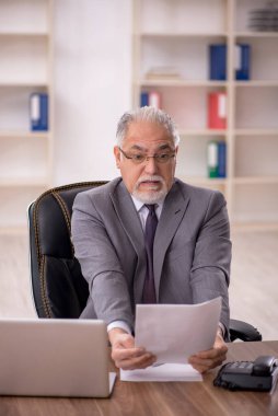 Ofiste çalışan eski bir işadamı.