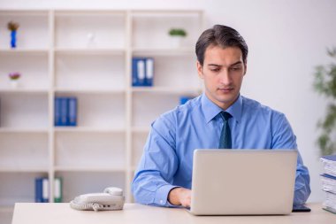 Genç işadamı ve işyerinde çok fazla iş var.