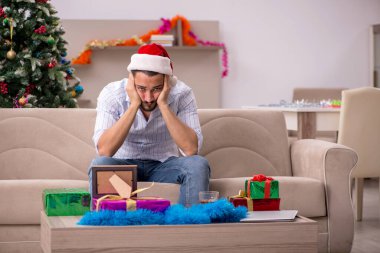 Genç adam yeni yılı evde yalnız kutluyor.