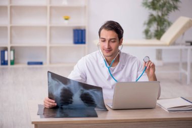 Genç erkek doktor radyoloji uzmanı hastanede çalışıyor.