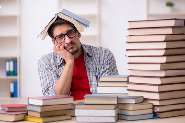 Genç bir öğrenci ve sınıfta çok fazla kitap var.