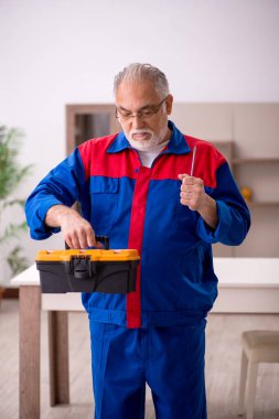 Evde çalışan yaşlı marangoz.