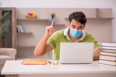 Genç öğrenci salgın sırasında evde sınavlara hazırlanıyor.