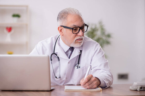 Old male doctor working at the hospital
