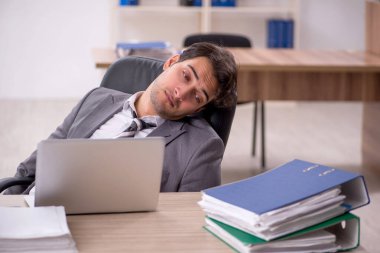 Ofisteki aşırı işten memnun olmayan genç bir çalışan.