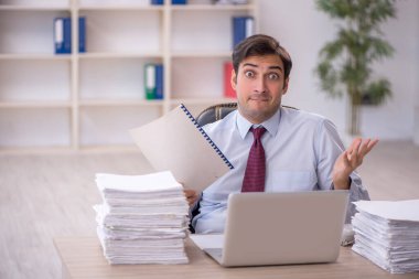 Genç işadamı ve ofiste çok fazla iş var.