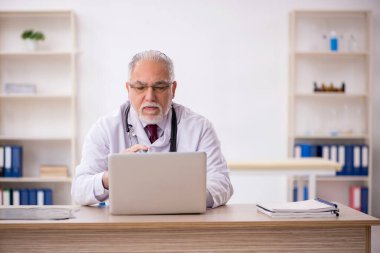 Klinikte çalışan yaşlı bir doktor.