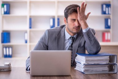 Ofisteki aşırı işten memnun olmayan genç bir çalışan.