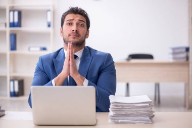 Genç işadamı ve işyerinde çok fazla iş var.