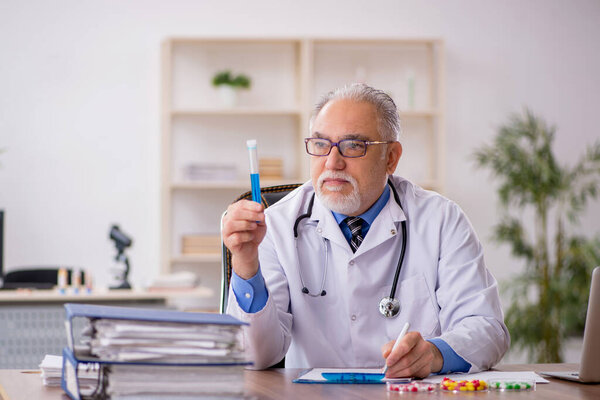 Old doctor pharmacist in drugs synthesis concept