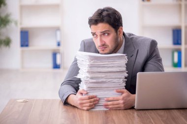 Genç bir çalışan ve ofiste çok fazla iş var.