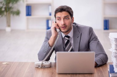 Genç bir çalışan ve ofiste çok fazla iş var.