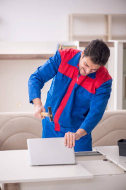 Evde çalışan genç bir marangoz.