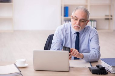 Old employee working at workplace