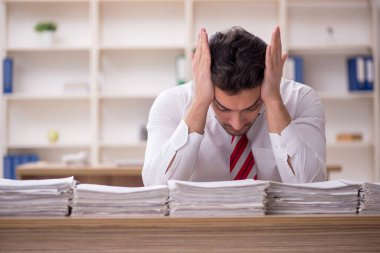 Genç işadamı ve işyerinde çok fazla iş var.
