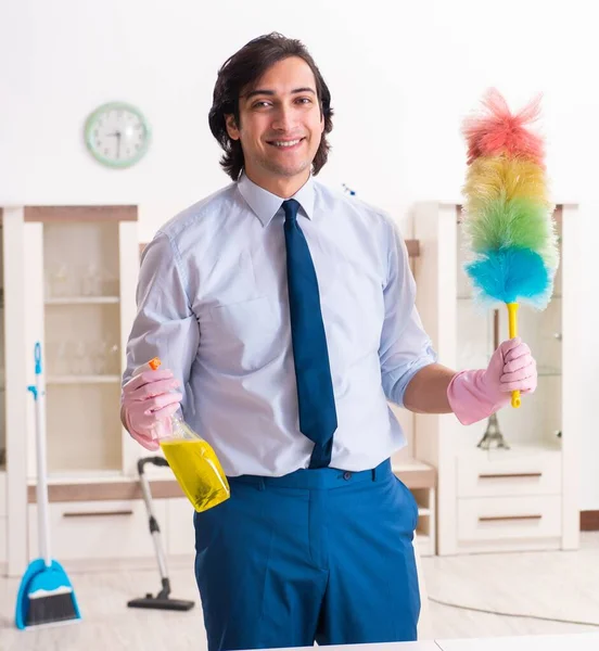 Genç işadamı evi temizliyor.