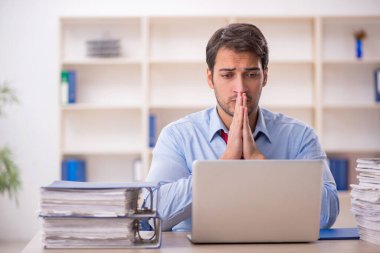 Genç işadamı ve işyerinde çok fazla iş var.