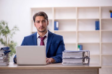 Genç işadamı ve işyerinde çok fazla iş var.