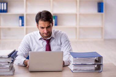 Genç işadamı ve işyerinde çok fazla iş var.