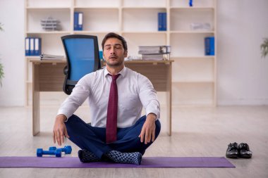 Mola sırasında spor yapan genç bir çalışan.