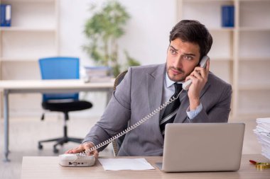 Genç işadamı ve ofiste çok fazla iş var.