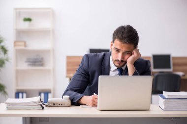 Genç işadamı işyerinde oturuyor.