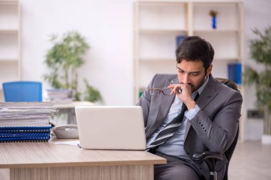 Genç işadamı ve ofiste çok fazla iş var.