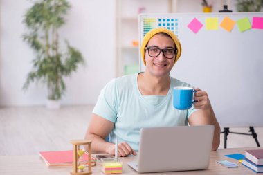 Genç tasarımcı ofiste oturuyor.