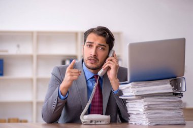 Genç işadamı işyerinde oturuyor.