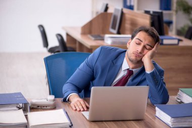 Genç işadamı işyerinde aşırı çalışmaktan memnun değil.