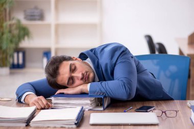 Genç işadamı işyerinde aşırı çalışmaktan memnun değil.