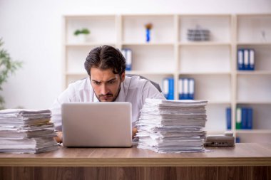 Genç işadamı ve ofiste çok fazla iş var.