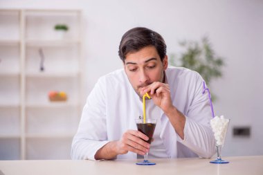 Laboratuvarda alkolsüz içeceği inceleyen genç bir kimyager.