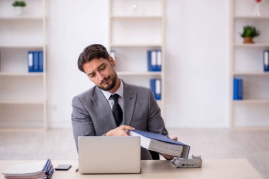 Genç işadamı işyerinde oturuyor.