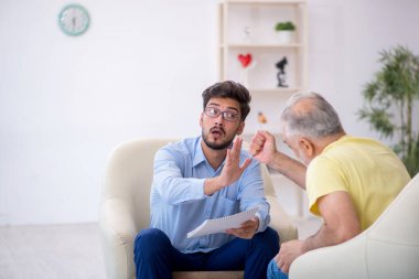 Yaşlı adam genç psikoterapisti ziyaret ediyor.