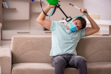 Genç müteahhit evde haşere kontrolü yapıyor.