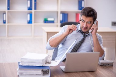 Ofisteki aşırı işten memnun olmayan genç bir çalışan.