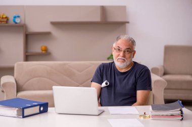 Yaşlı adam salgın sırasında evden çalışıyor.