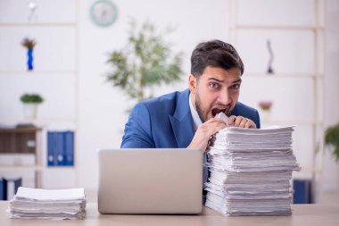 Genç bir çalışan ve ofiste çok fazla iş var.