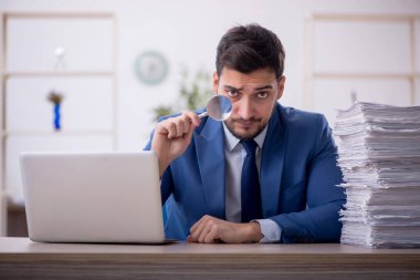 Genç bir çalışan ve ofiste çok fazla iş var.