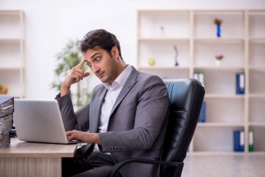 Genç işadamı ve ofiste çok fazla iş var.