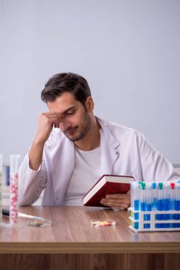 Young chemist in front of white board