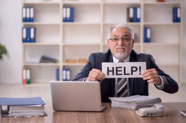 Old businessman employee unhappy with excessive work at workplace